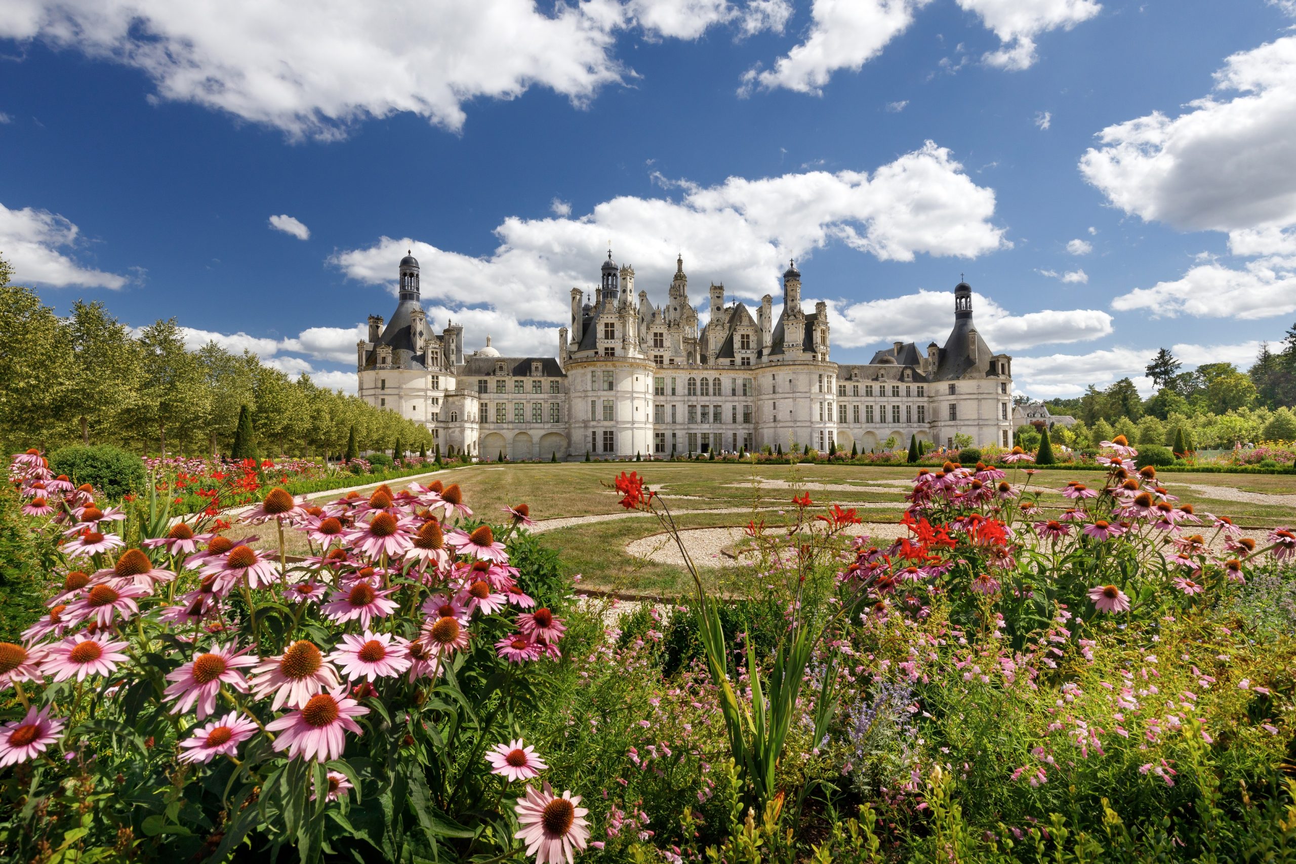 Majestic Château de Chambord mirrored in the calm waters on a clear day.